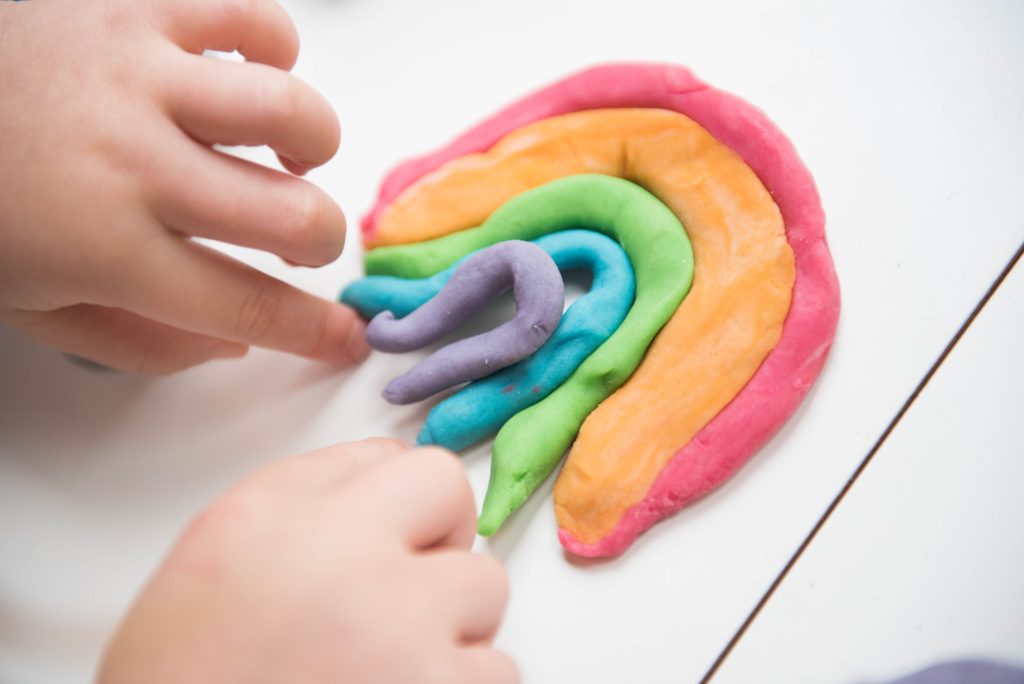 A child makes a playdough rainbow as part of preschool 5 senses activities.  Simple Activities for Preschoolers